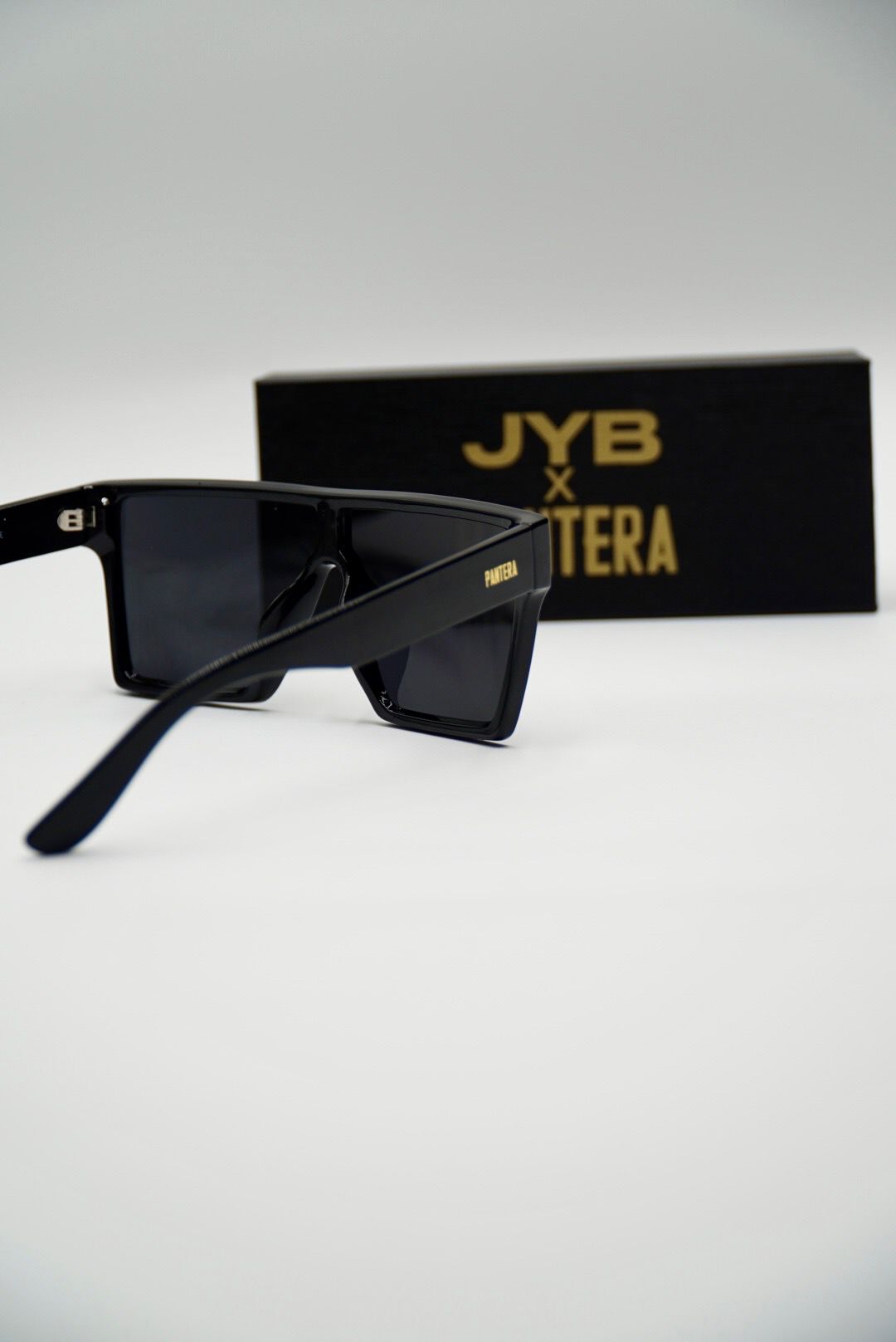 Black sunglasses with 'JYB' branding on a white background